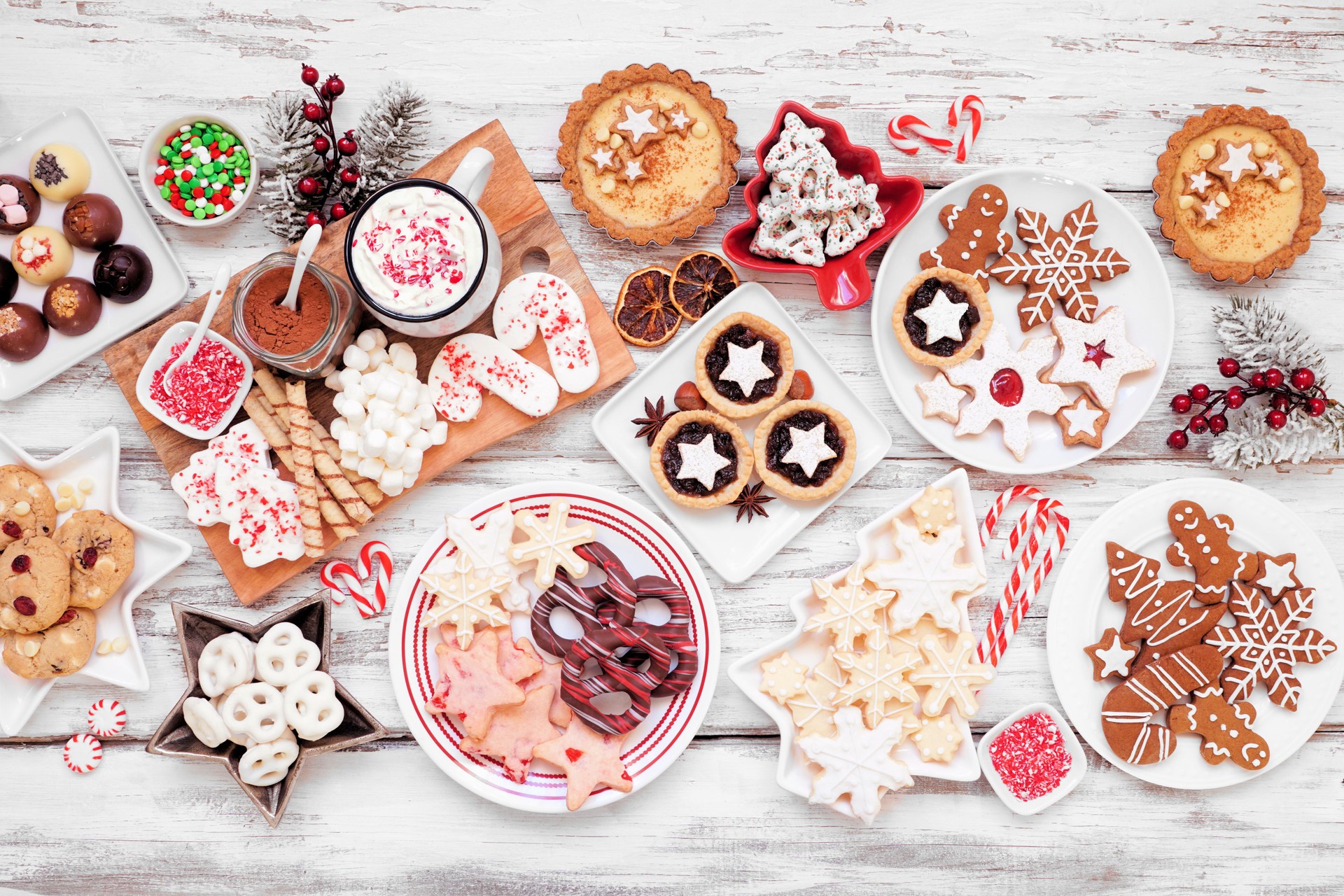 Christmas holiday cookies and desserts table scene on a white wood background